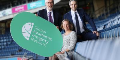 QQI CEO, Padraig Walsh; Helen Gniel, Director, TEQSA Higher Education Integrity Unit and Mr Simon Harris TD, Minister for Further and Higher Education, Research, Innovation and Science holding a Global Academic Integrity Network sign at the launch of the network in Croke Park. 