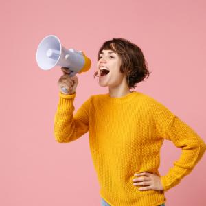 Funny young brunette woman girl in yellow sweater posing isolated on pastel pink wall background studio portrait.