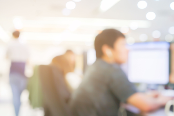blurred photograph of students in brightly lit computer lab on campus