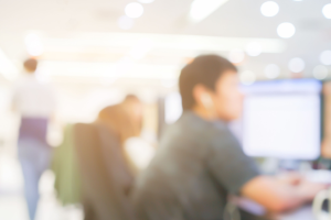 blurred photograph of students in brightly lit computer lab on campus