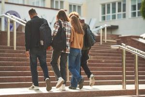 Four learners walking up a flight of stairs together