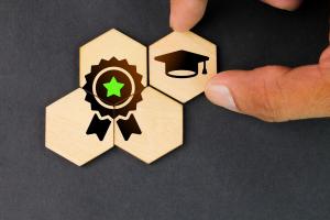 wooden blocks with icons of a graduation hat and an achievement mark