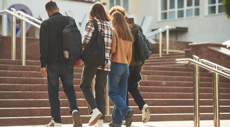 Four learners walking up a flight of stairs together